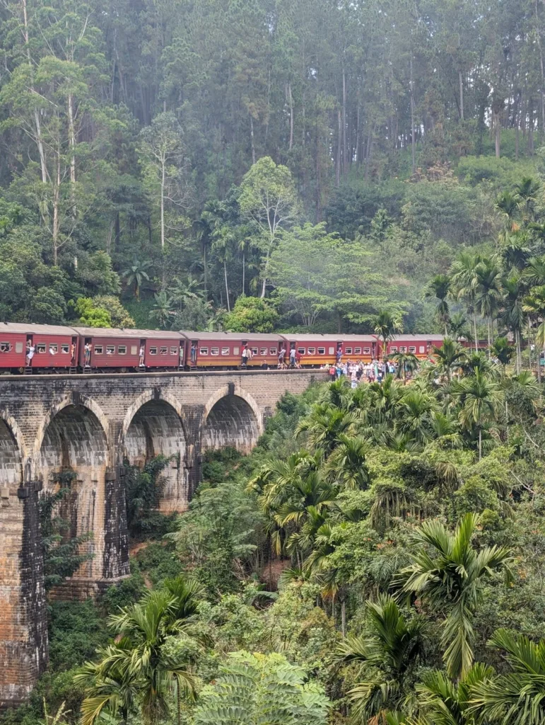 Train rouge traversant le Nine Arch Bridge à Ella, Sri Lanka
