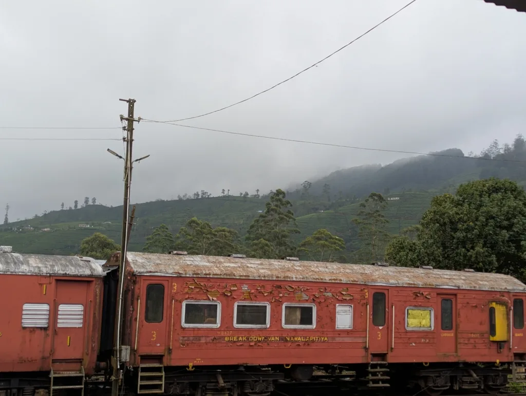Wagon à l’arrêt dans une petite gare de montagne, collines en arrière-plan