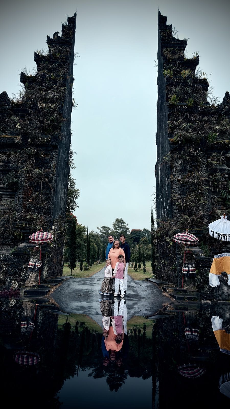 Notre famille entre les deux tours du Bali Handara Gate, avec le reflet dans une flaque