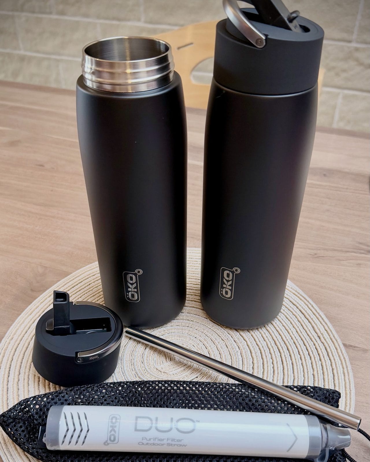 Contenu de la boîte de la gourde filtrante isotherme ÖKO Duo : deux gourdes en inox, le bouchon à paille, la paille métallique et le filtre Purifier