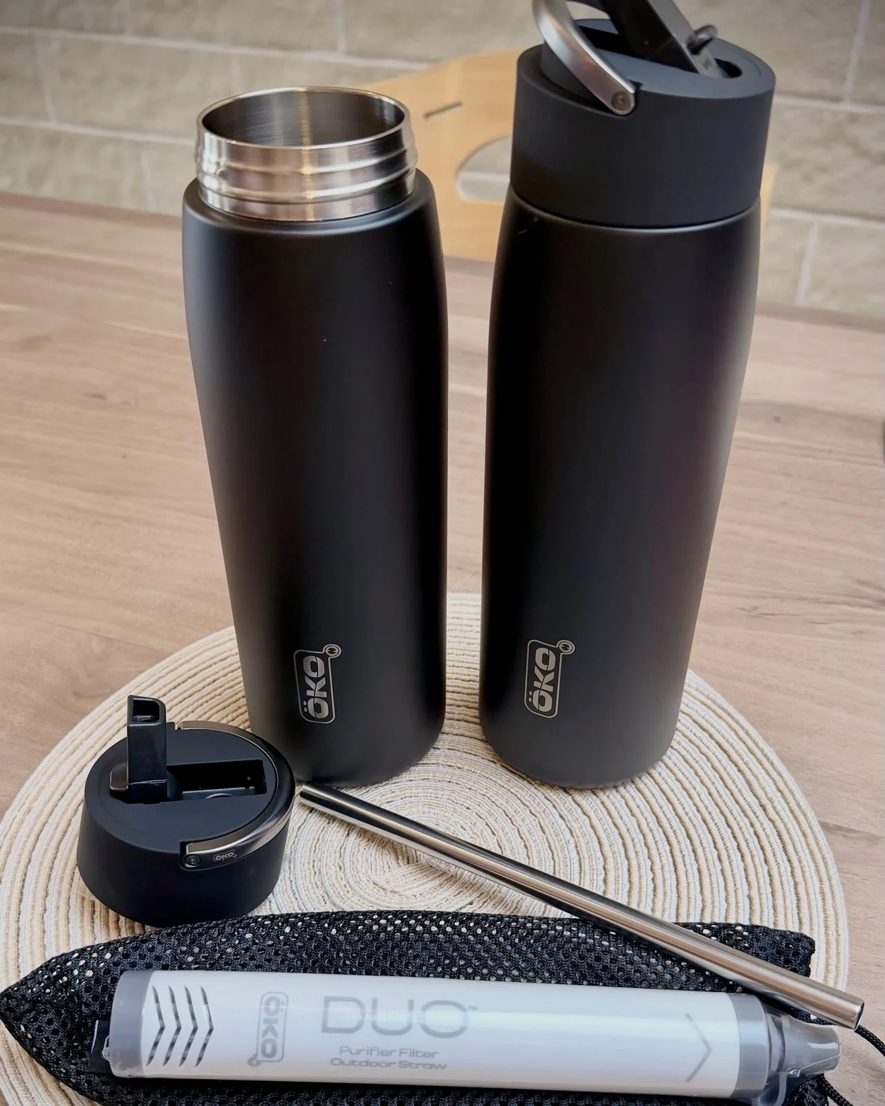 Contenu de la boîte de la gourde filtrante isotherme ÖKO Duo : deux gourdes en inox, le bouchon à paille, la paille métallique et le filtre Purifier