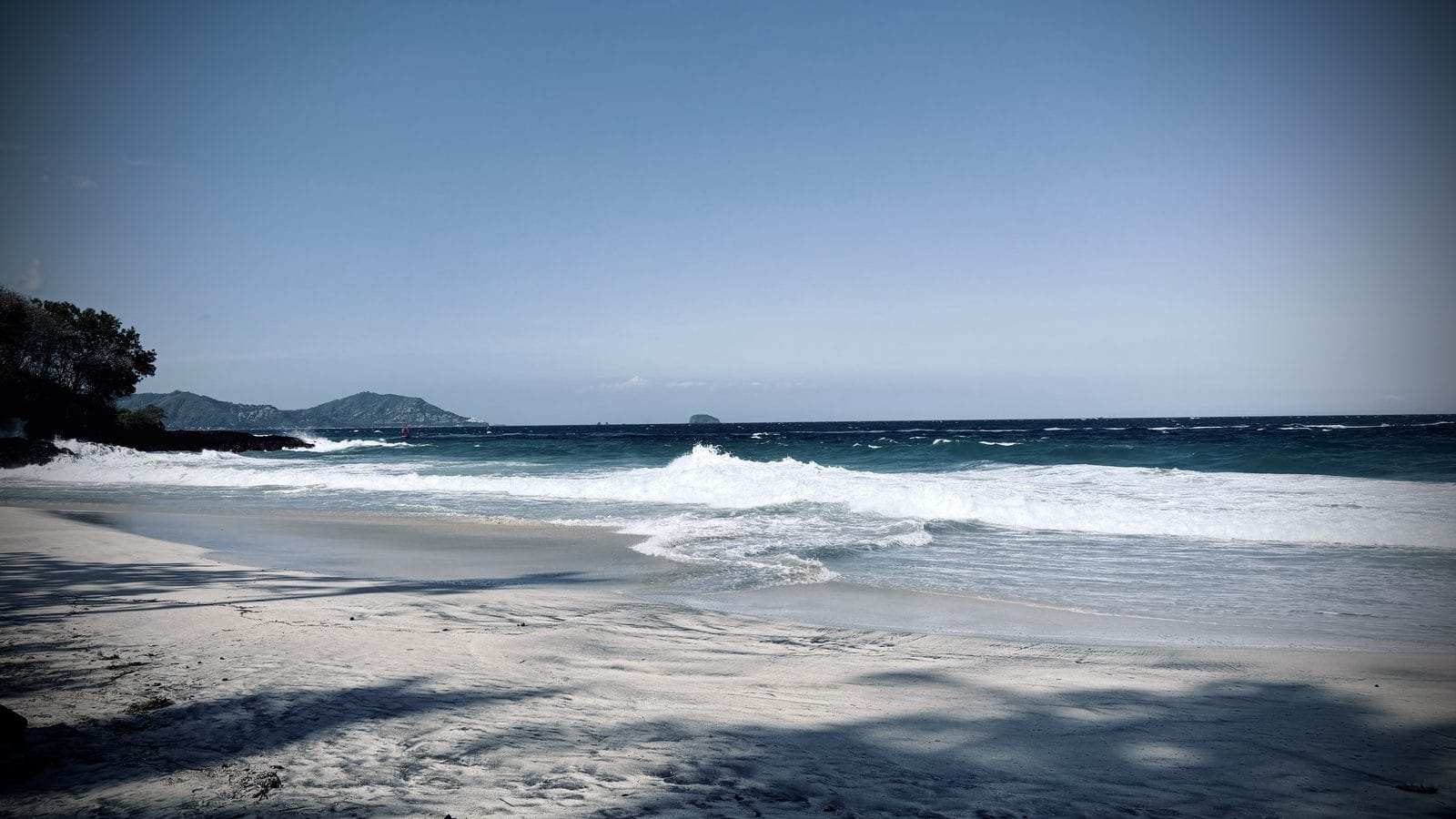 La plage de sable blanc de Bias Tugel et ses vagues, près de Manggis