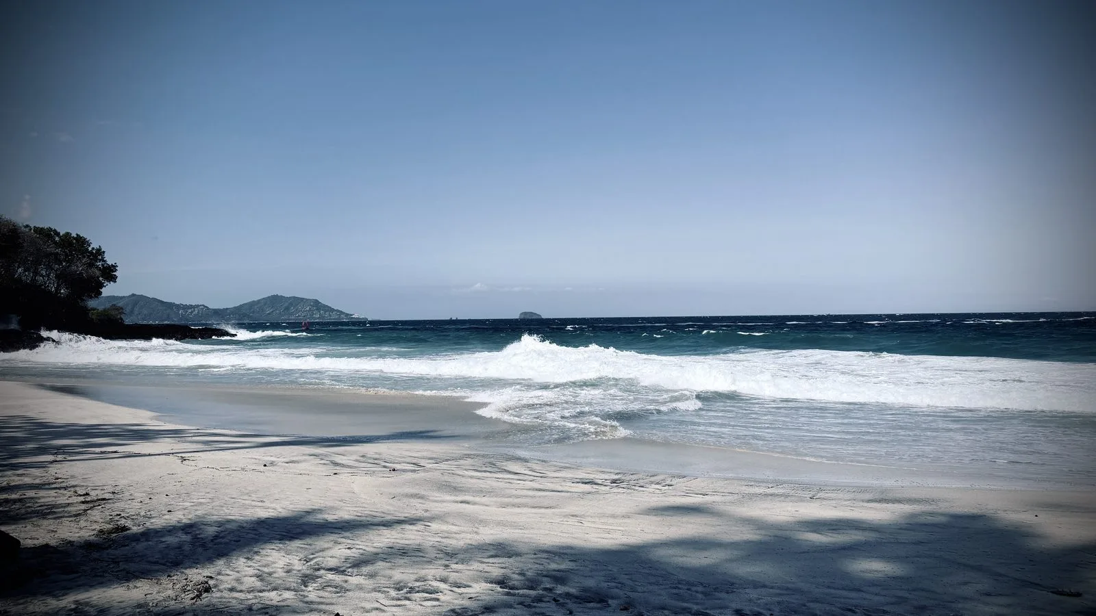 La plage de sable blanc de Bias Tugel et ses vagues, près de Manggis