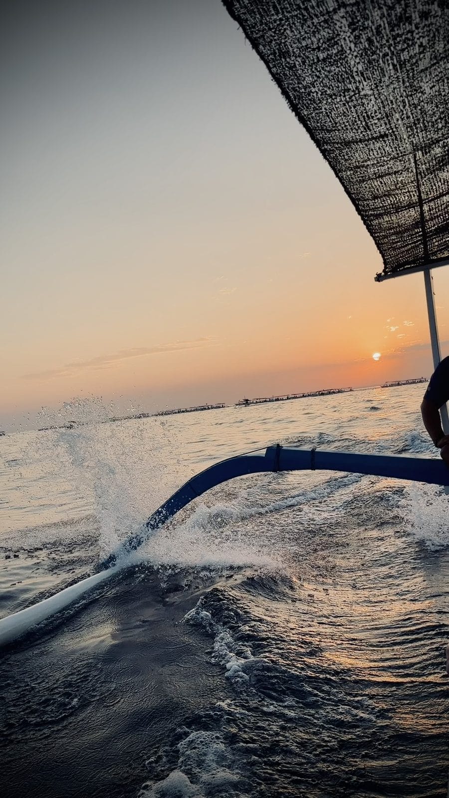 Lever de soleil depuis un bateau traditionnel à balancier au large de Lovina