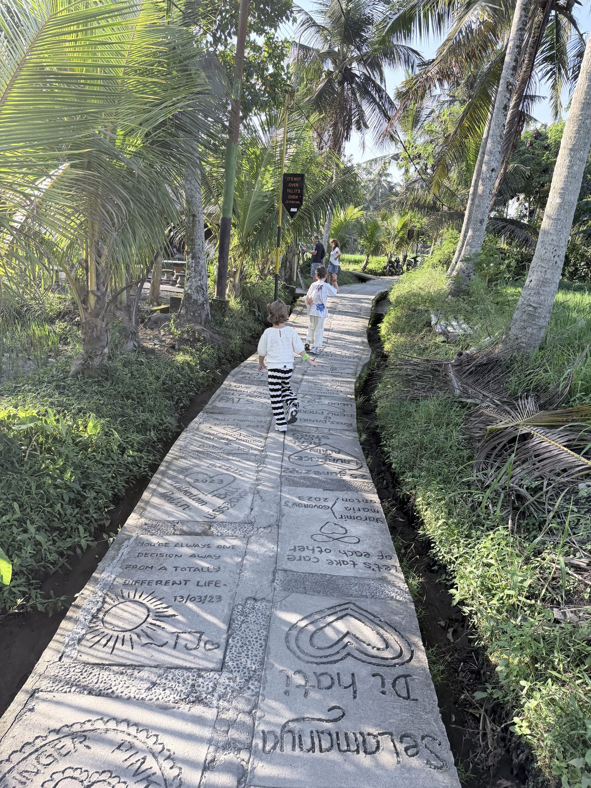 Nos enfants sur le chemin pavé de messages du Sweet Orange Walk à Ubud